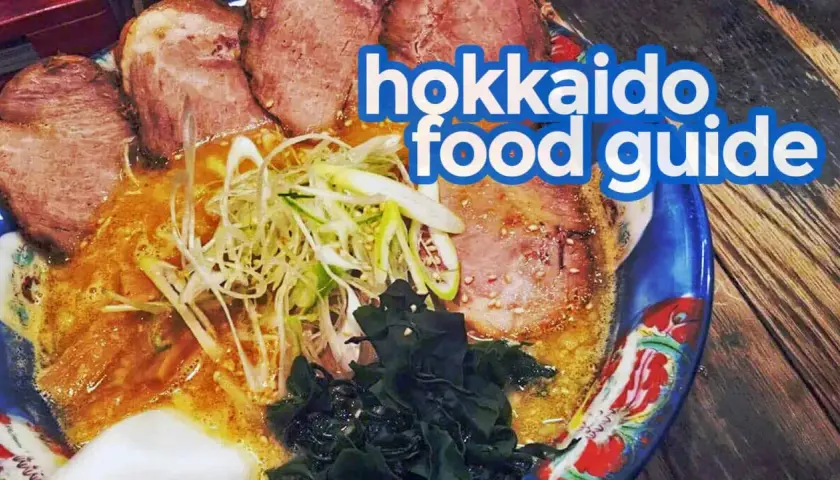 A steaming bowl of ramen, a quintessential Hokkaido food, features tender chashu pork, green onions, and seaweed in a rich broth.