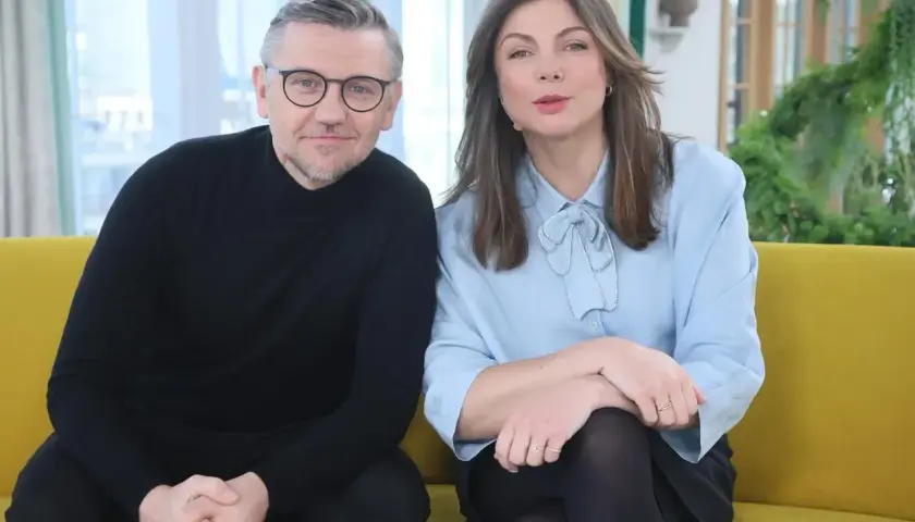 Krzysztof Czeczot z żoną, uśmiechnięci, siedzą na kanapie.