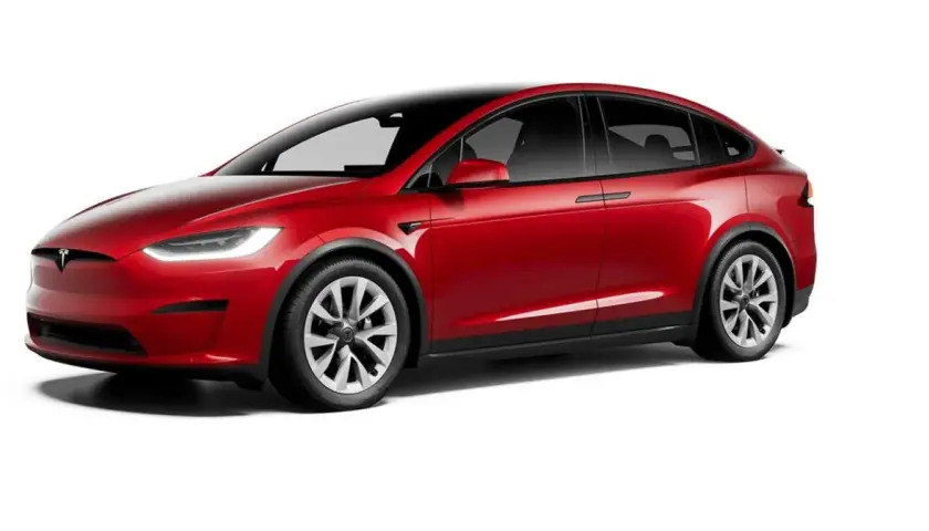Czerwony Tesla X z czarnym dachem i przyciemnianymi szybami, prezentujący nowoczesny design i elektryczną moc.