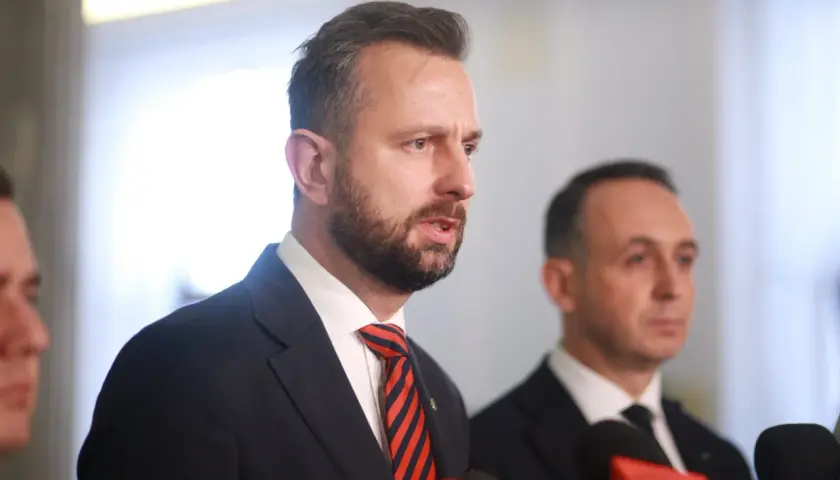 Politycy w garniturach, jeden z nich przemawia. Fani polityki spekulują o dymisji ministra rolnictwa przed marcem 2026.