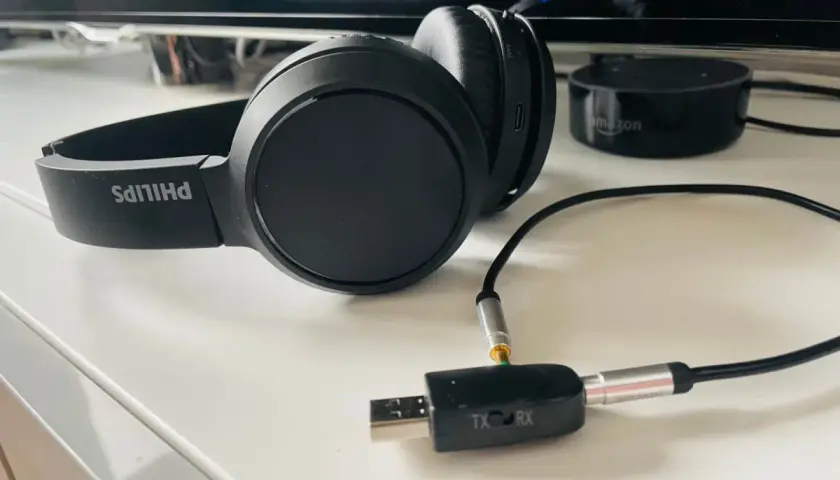 Czarne słuchawki Philips z adapterem USB-jack, pokazujące, jak podłączyć słuchawki do telefonu Samsung.