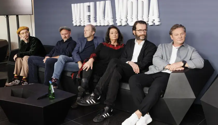 Wielka woda obsada siedzi na kanapie. W tle biały napis "WIELKA WODA".