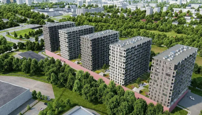 Nowoczesne bloki mieszkalne otoczone zielenią, z widokiem na miasto pod **tuwima sky**.