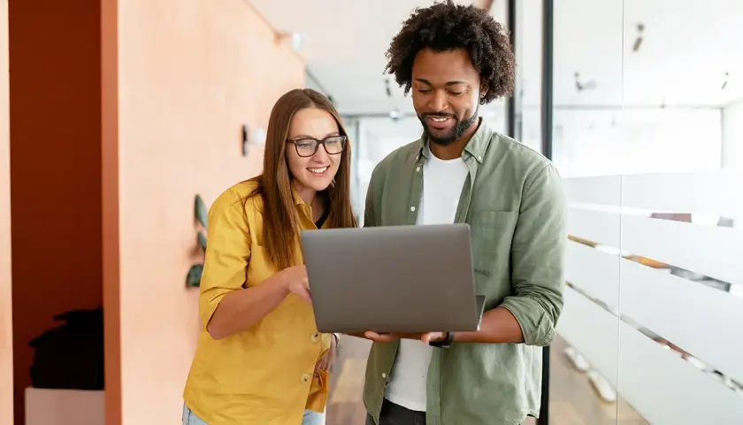 A woman and man discuss public administration vs public policy on a laptop.