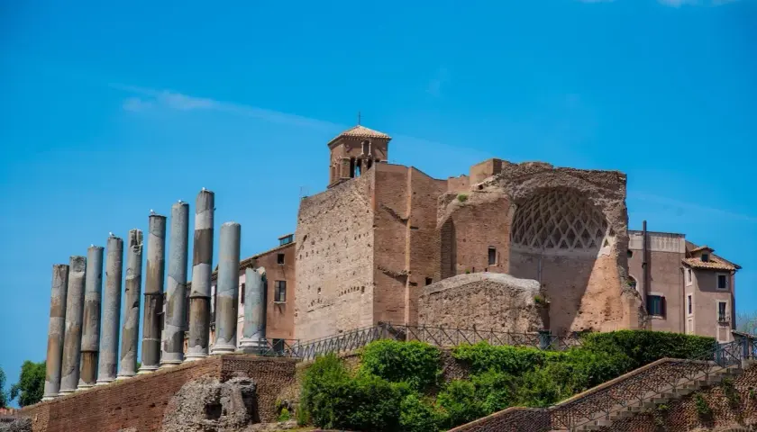 Resti antichi a Roma, tra cui colonne e mura di mattoni, evocano la grandezza della Domus Aurea.
