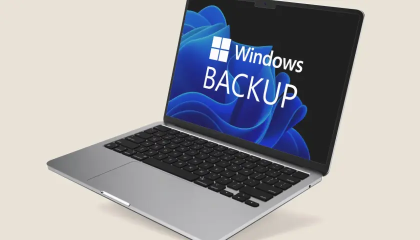 Ein Laptop mit dem Windows 11 Backup-Logo auf dem Bildschirm. Der Dateiversionsverlauf von Windows 11 sichert Ihre Daten.