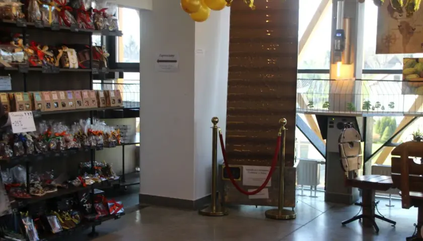 Wnętrze pijalni czekolady w Sanoku. Półki uginają się pod ciężarem słodkości, a złote balony zapowiadają wyjątkowe okazje.
