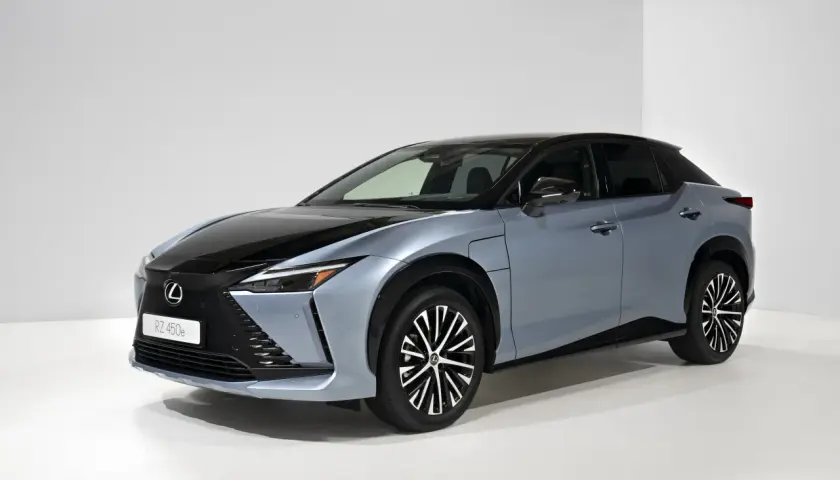 Elegancki, niebieski Lexus RZ 450e z czarnym dachem i futurystycznymi felgami stoi na białym tle.