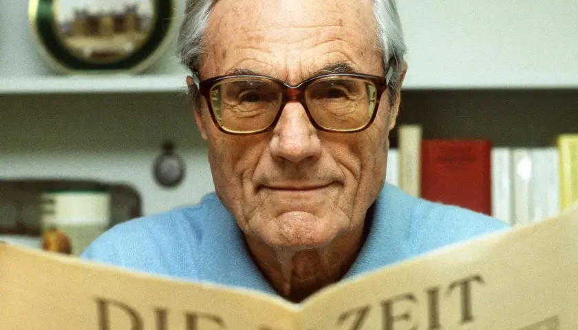 Gerd Bucerius, mit Brille und einem Lächeln, liest die Zeitung "DIE ZEIT".