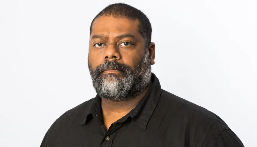 En man med skägg, baker Karim, tittar rakt fram.