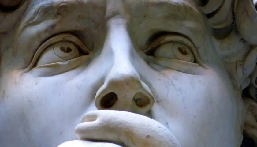 Close-up of Michelangelo's David sculpture, focusing on the eyes, nose, and mouth.