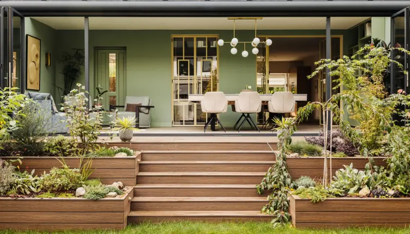 Schöne Ideen für einen kleinen Wintergarten: grüne Wände, bequeme Sitzmöbel und ein Essbereich mit moderner Beleuchtung.