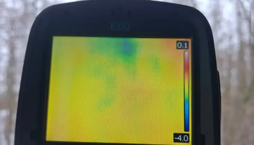 Ekran kamery termowizyjnej E60 pokazuje rozkład temperatur. Badanie kamerą termowizyjną ujawnia chłodniejsze obszary w zielono-niebieskim paśmie.