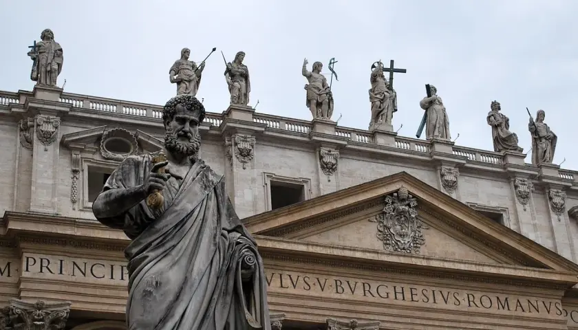 Kamienna postać z kluczem w dłoni, na tle bazyliki. Czy mantry są niebezpieczne? Ta rzeźba nie daje odpowiedzi.