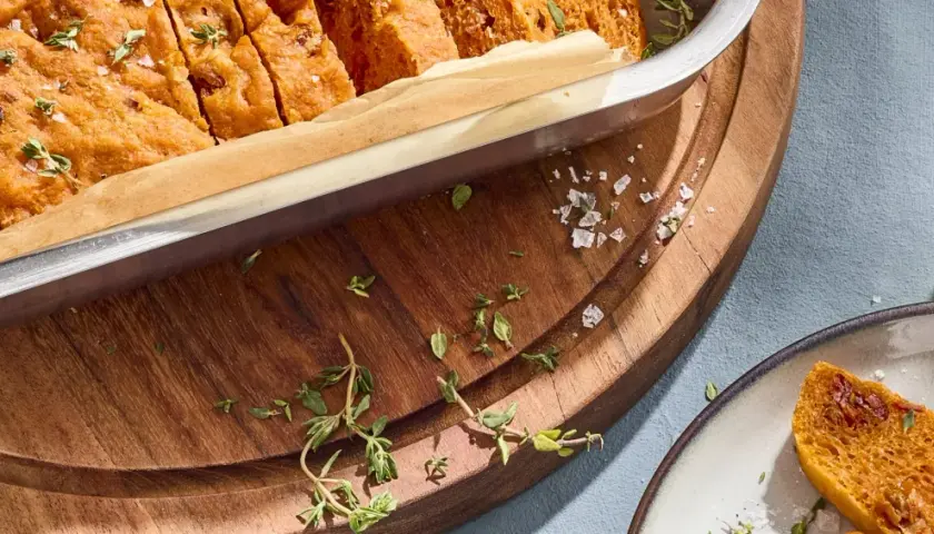 Frisch gebackene focaccia mit tomaten, bestreut mit Meersalz und Thymian, bereit zum Genießen.