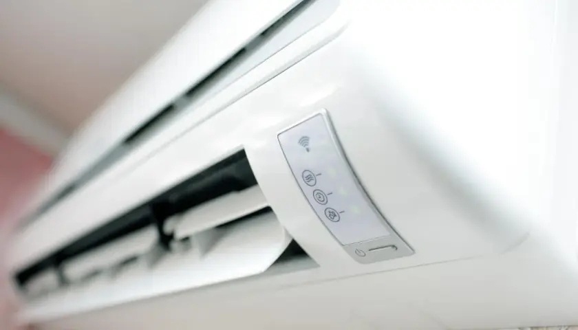 Un moderno aire acondicionado blanco con iconos de Wi-Fi y temperatura. El significado del aire acondicionado es confort y bienestar en el hogar.