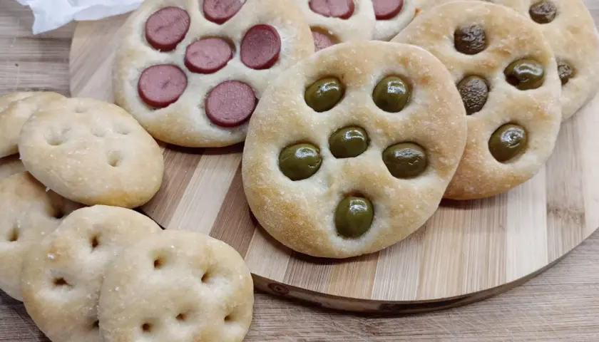 Focaccine di semola con olive e wurstel, pronte per essere gustate.