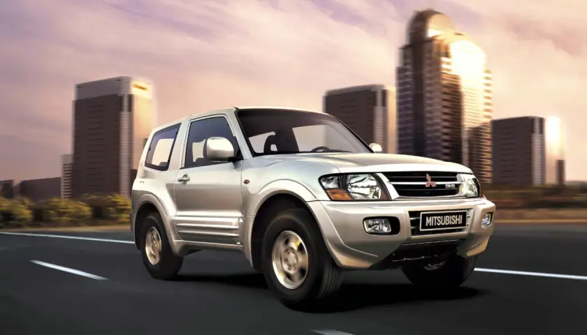 Silver Mitsubishi Montero 3.2 DID en movimiento, con edificios modernos de fondo. A pesar de su robustez, algunos propietarios han reportado problemas.