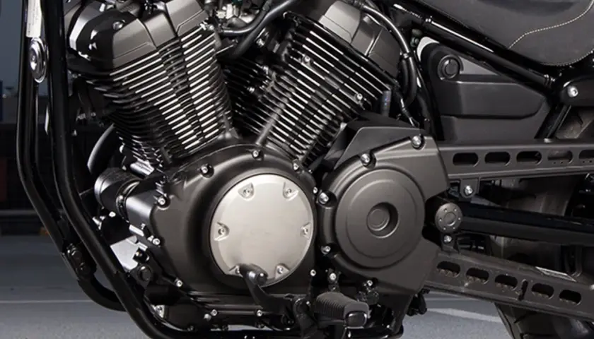 Silnik V-twin motocykla Yamaha XV950, z charakterystycznymi żebrowanymi cylindrami i czarnymi osłonami.