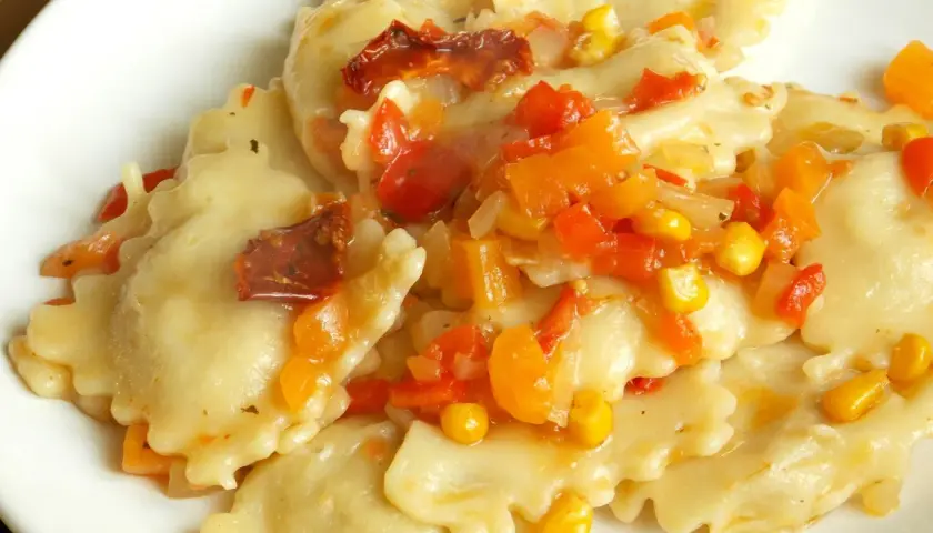 Ravioli z kolorowym sosem warzywnym, w tym kukurydzą i suszonymi pomidorami. Pyszny sos do ravioli.