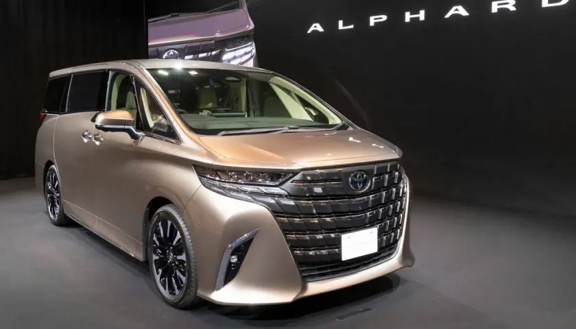 Elegancki, brązowy Toyota Alphard prezentuje się na czarnym tle.