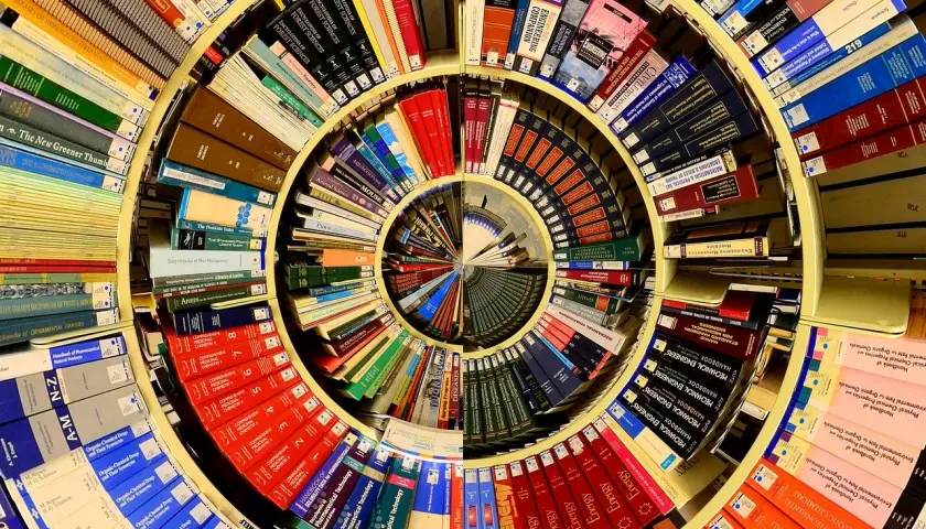 Książki ułożone w spiralę, tworząc okrąg. Wśród nich "piotr kościelny cykl mikun".