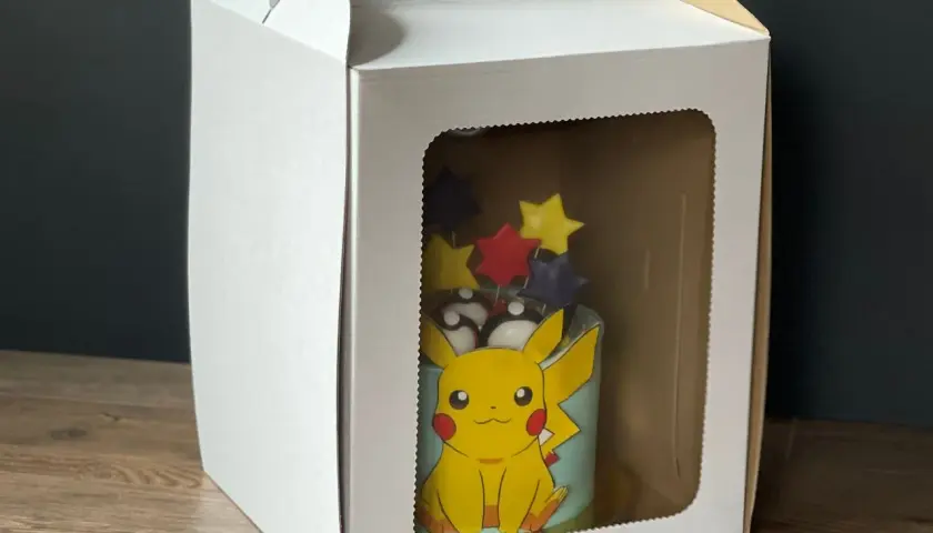 Tort z Pikachu w białym pudełku z okienkiem.
