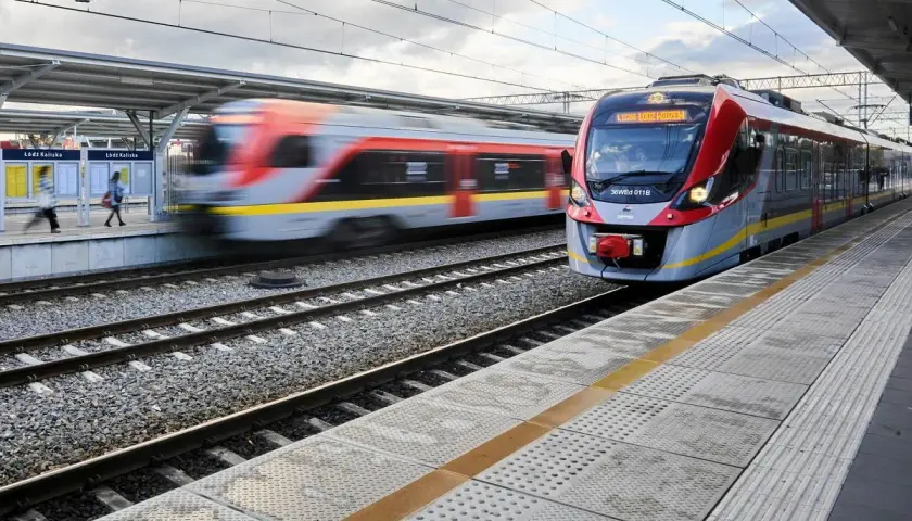 Nowoczesny pociąg PKP Intercity zbliża się do stacji Łódź Kaliska. W tle widać drugi pociąg w ruchu.
