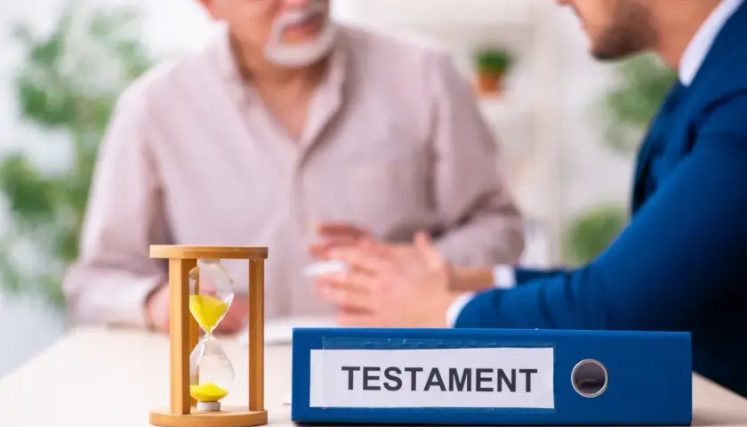 Klepsydra i segregator z napisem "TESTAMENT" na stole, podczas rozmowy dwóch mężczyzn.