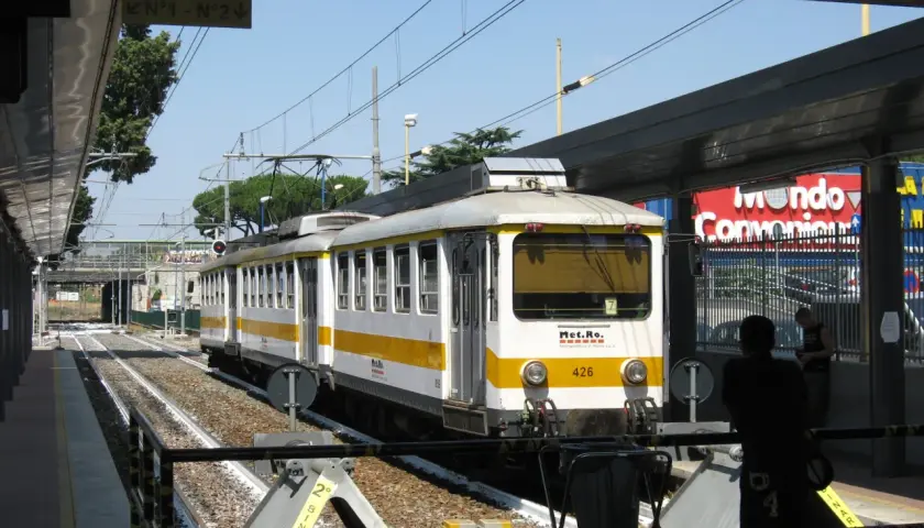 Treno della metro C a Torrenova, con segnale "Binario N°1 - N°2". Persone in attesa sul binario.
