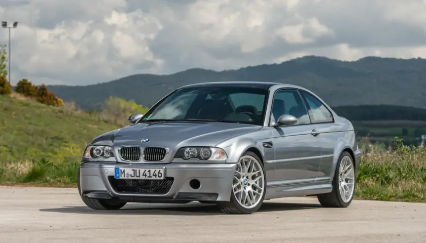 Srebrne BMW E46 coupe na tle górskiego krajobrazu.