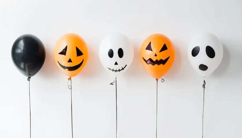 Fünf Ballons für Halloween basteln: ein schwarzer, zwei Kürbis-Ballons und zwei Geister-Ballons.