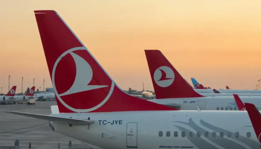 O zachodzie słońca samoloty Turkish Airlines czekają na pasażerów i ich bagaż.