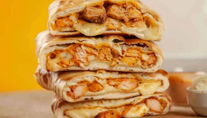 Scaccia ragusana ripiena di pollo e formaggio filante, un sapore unico.