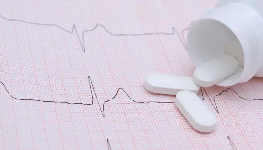 Vita tabletter, som kan vara betablockerare mot ångest, ligger utspridda på ett EKG-papper.