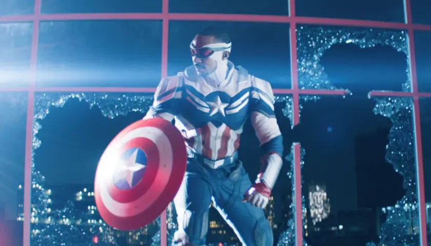 Sam Wilson, nouveau Captain America, prêt pour sa sortie MCU, tient son bouclier devant une fenêtre brisée.