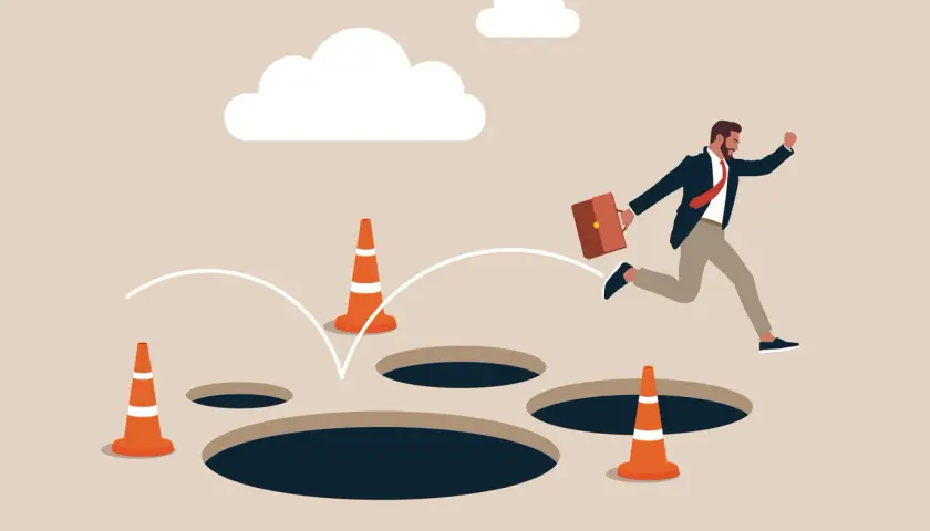 Un homme d'affaires saute par-dessus des trous, symbolisant les dangers du processus d'achat immobilier.