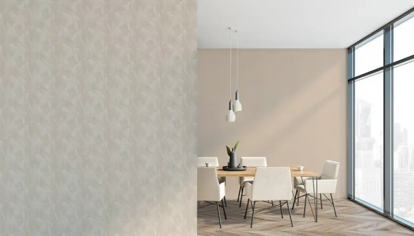 Zwei Tapeten kombinieren: Eine Wand mit geometrischem Muster, daneben ein Essbereich mit schlichter Wandfarbe, Holztisch und Stühlen.