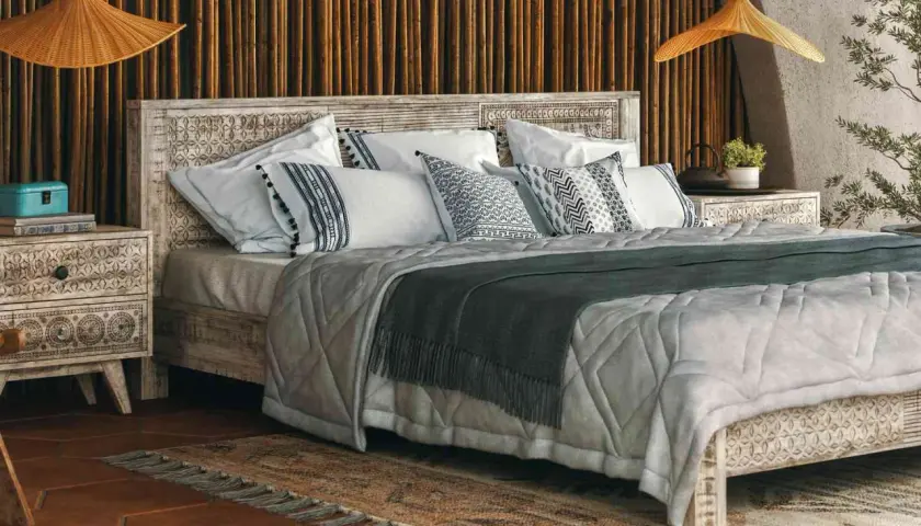 A cozy bedroom with a carved wooden bed, featuring decorative pillow shams. Can you sleep on pillow shams? Yes, they add comfort and style.