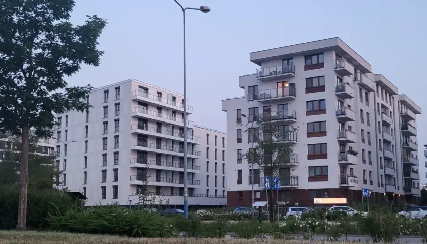 Nowoczesne bloki mieszkalne z balkonami na tle błękitnego nieba.