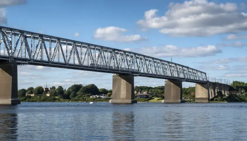 Lilla Bältbron, en imponerande järnvägsbro, sträcker sig över vattnet. Dess pris är väl värt den natursköna utsikten och den viktiga förbindelsen den utgör.