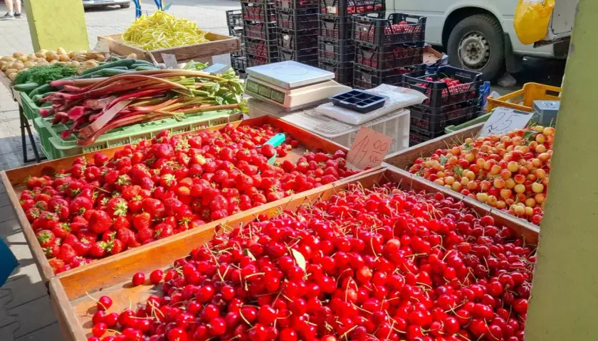 Targowisko pełne świeżych owoców. Duże skrzynie z truskawkami i czereśniami. Sprawdź czereśnie cenę za kilogram!