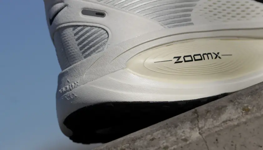 Biały but sportowy z napisem ZOOMX. To jest ten słynny "drop" w butach, który wpływa na komfort biegu.