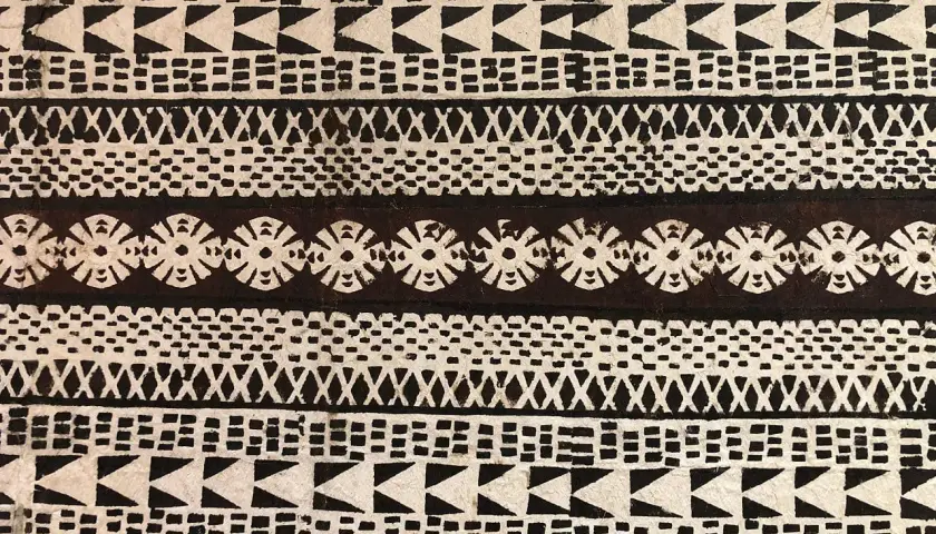Wzory przypominające tatuaże polinezyjskie, z ich bogatym znaczeniem, zdobią tkaninę. Linie pełne symboli i geometrycznych kształtów.