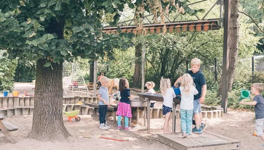 Kinder spielen im Sandkasten auf dem Gelände eines evangelischen Kindergartens.
