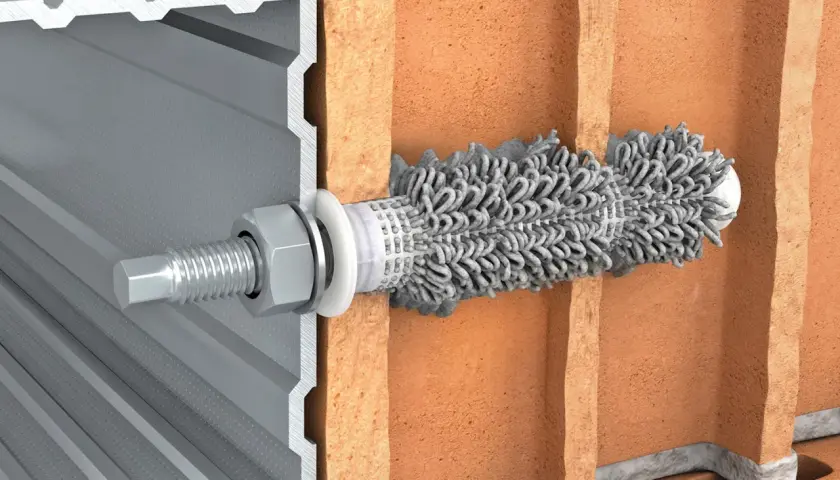 Przekrój przez cegłę Porotherm z zamocowaną kotwą i profilem aluminiowym.
