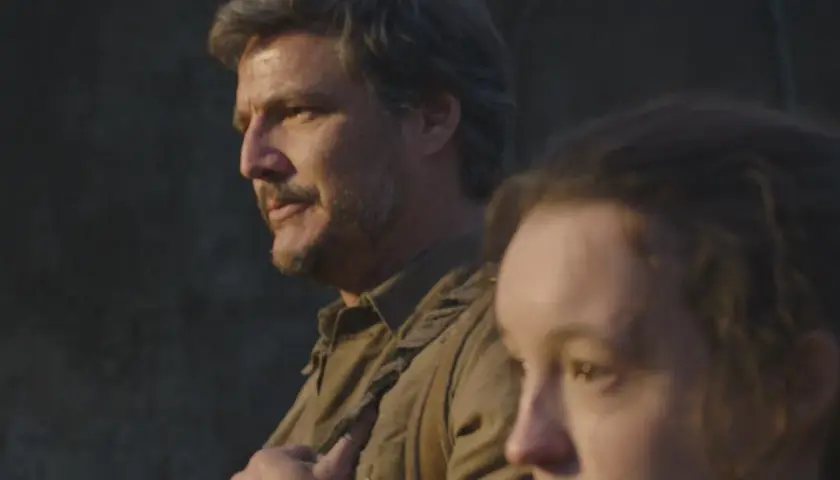 Joel i Ellie z serialu The Last of Us na tle ciemnej ściany.