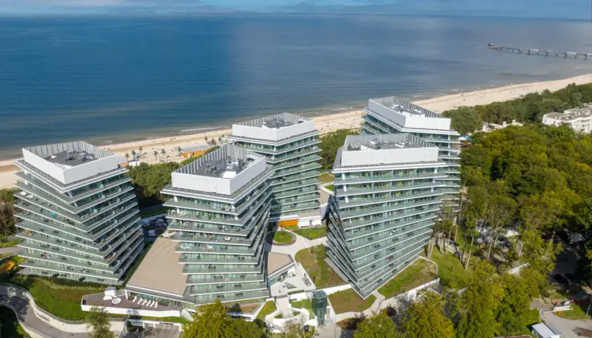 Nowoczesny wave resort z tarasami i widokiem na morze. Architektura idealnie wkomponowana w nadmorski krajobraz.