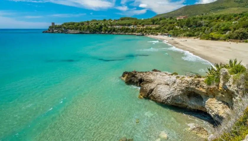 Acque cristalline e una spiaggia dorata incorniciano la **costiera cilentana**, con una torre antica a guardia del mare.