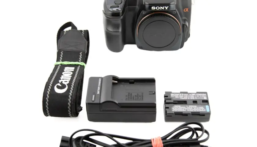 Zestaw z aparatem Sony Alpha A100: korpus, pasek Canon, ładowarka i bateria Sony NP-FM55H.